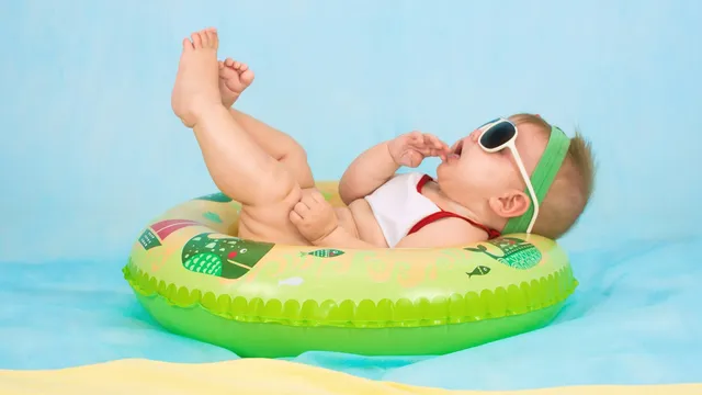 Baby met zwembandje aan de rand van een ondiep kinderbad